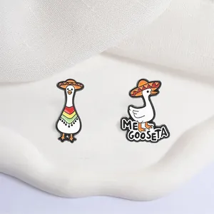 Detailed close-up of funny Mexican hat white goose enamel pins with Me Goose Ta text design