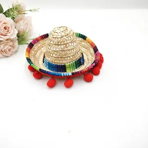 Mini Mexican straw hat with colorful trim and red pom-poms for party decor