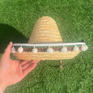 Handcrafted Mexican straw sombrero hat featuring colorful trim and white pom-poms for party