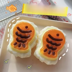 Detailed macro view of two squishy Taiyaki stress relief toys in a cream tray