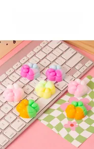 Close-up van kleurrijke kattenpoot-squishy-speeltjes op een roze toetsenbord