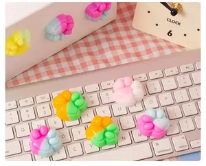 Colorful cat paw-shaped squishy stress relief toys displayed on a white laptop keyboard