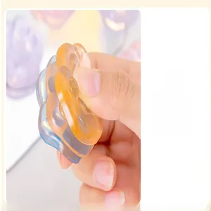 Macro view of hand squeezing a soft colorful cat paw jelly squishy toy for stress relief