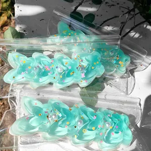 Mint green translucent butterfly squishy toy with glitter and pearls in clear packaging