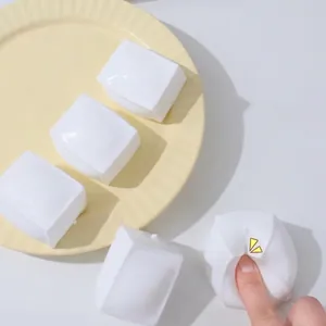 Gros plan d'un jouet antistress en forme de tofu blanc avec une texture très souple.