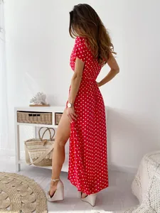 Abito lungo rosso a pois con spacco alto e silhouette fluida dal design elegante.