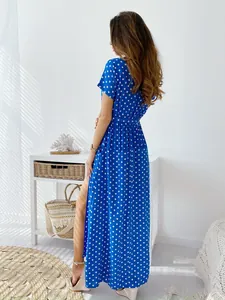 Vista posteriore di un abito lungo blu a pois con maniche corte e spacco laterale