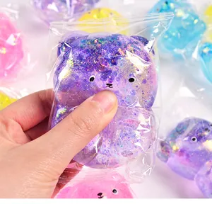 Detailopname van een paarse glitterende aurora beer squishy toy die wordt geknepen.