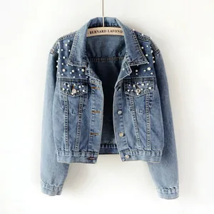Close-up of women's cropped denim jacket with elegant white pearl embellishments