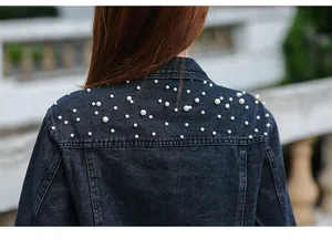 Detailed view of white pearl bead embellishments on a classic women's denim jacket