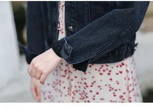 High quality close-up showing the sleeve and button texture of a women's denim jacket