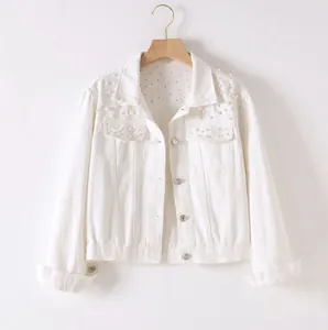 Detailed view of white short denim jacket featuring elegant pearl bead shoulder detailing