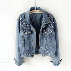 Detail view of women's short denim jacket with delicate pearl embellishments.