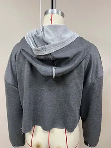 Detaillierte Rückansicht eines grauen, locker sitzenden Crop-Hoodies auf einer Schaufensterpuppe.