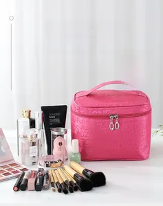 Vista dettagliata della grande borsa da trucco rosa con pennelli e accessori vari