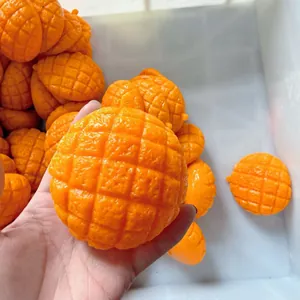 Primer plano de un juguete squishy de pan de piña naranja con textura detallada