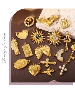 Dettaglio di vari ciondoli vintage placcati in oro a forma di cuore, croce e sole