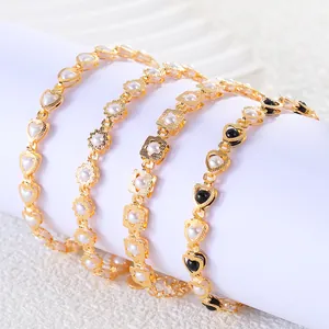Detail view of four gold-toned heart and pearl bracelets wrapped on a white prop.