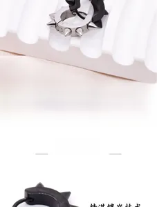 Macro view of edgy stainless steel spiked rivet ear cuffs on a modern white display tray