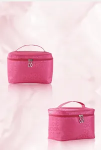 Vista frontale e laterale di una borsa per trucchi rosa con manico e motivo.