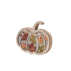Illuminated wooden pumpkin table decoration with autumn maple leaves for Thanksgiving