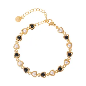 Elegant gold heart link bracelet featuring alternating black and white pearls with lobster clasp