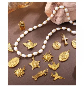 Vista dettagliata di ciondoli vintage placcati oro con croce, angeli e collana di perle