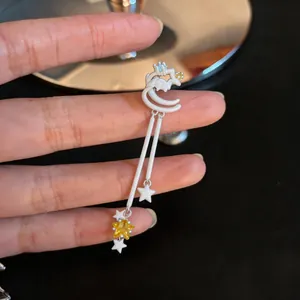 Close-up detail of white star ear cuff with yellow zircon and hanging star tassels