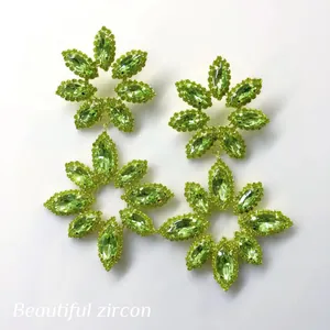 Detailed macro view of luxury green crystal flower-shaped dangle earrings jewelry