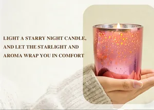 Detail shot of a lit aromatherapy candle in a starry sky glass cup held by hands