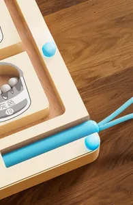 Close-up view of the magnetic pen storage slot on a wooden educational marble maze toy.