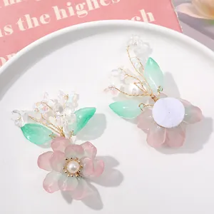 Detail van handgemaakte roze kristallen bloem met groene bladeren voor DIY haaraccessoires