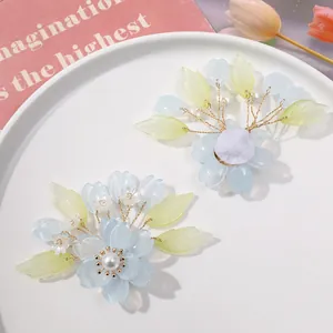 Detail van handgemaakte blauwe kristallen bloemen met groene bladeren voor DIY haaraccessoires