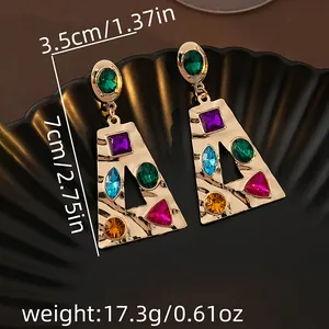 Détail de boucles d'oreilles géométriques avec strass de couleur et étiquettes de poids