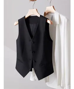 Professional detail of a black women's formal suit vest layered with white shirt
