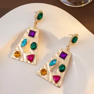 Détail macro de boucles d'oreilles dorées avec des strass en cristal multicolores