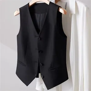 Close-up of a women's black cropped suit vest layered over a white shirt