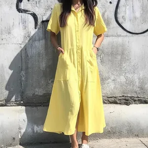 Detailed view of yellow short-sleeved shirt dress with pockets and waist pleats.