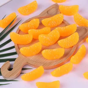 Detalle de juguetes blandos con forma de gajos de naranja realistas en bandeja