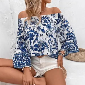 Detail view of women's blue floral off-the-shoulder long sleeve blouse with elegant pattern