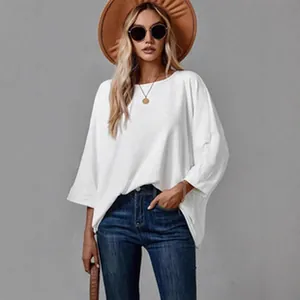 Close-up of a stylish white loose-knit long-sleeve top paired with accessories