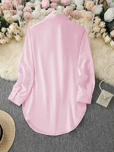 Elegant pink long sleeve ladies shirt featuring a curved irregular hemline back view detail