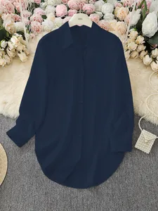 Detailed view of dark navy blue women's shirt with irregular hem on a styled background