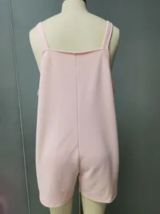 Detailed rear view of a solid pink textured fabric sleeveless romper shown on a mannequin.