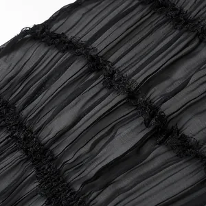 Primo piano dettagliato di elegante tessuto nero plissettato con bordi in pizzo
