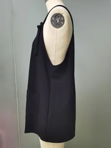 Side profile detail of black minimalist pocket strap romper jumpsuit shown on mannequin