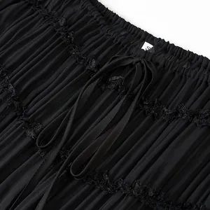 Primo piano dettagliato del tessuto plissettato nero con bordo in pizzo e laccetto decorativo