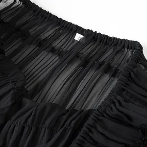 Dettaglio ravvicinato del tessuto in chiffon plissettato nero che mostra trama e fattura