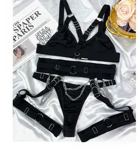 Dettaglio di un set di lingerie nera a quattro pezzi con catene d'argento e anelli di metallo.