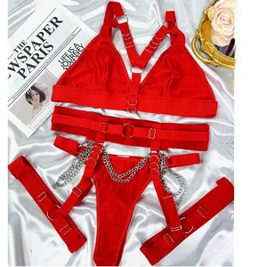 Dettaglio ravvicinato di un set di lingerie rossa sexy con catene metalliche e cinturini